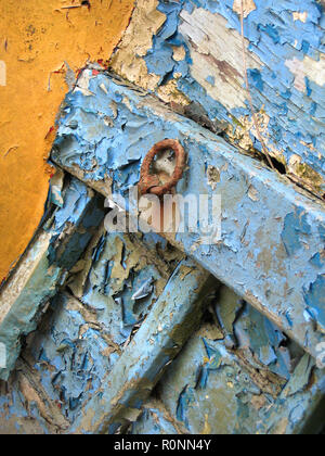 Sfaldante vernice blu e gialla all'interno dello scafo di un vecchio peschereccio abbandonato in legno sulle rive del fiume Dee, Kirkcudbright, Dumfries e Galloway, Scozia del sud-ovest Foto Stock