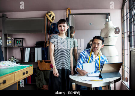 Giapponese maschio e femmina fashion designer che lavorano in uno studio. Foto Stock