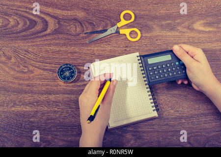 La scrittura a mano in un notebook bianco su sfondo marrone Foto Stock