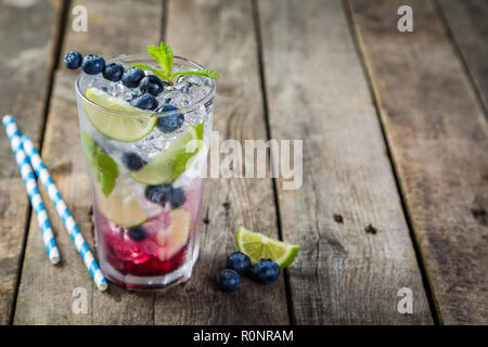 Mirtillo mojito in vetro su sfondo rustico Foto Stock