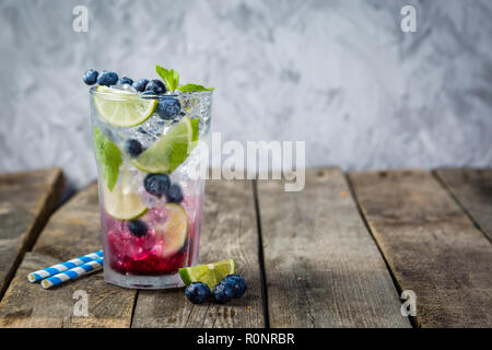 Mirtillo mojito in vetro su sfondo rustico Foto Stock