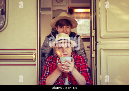 I turisti seduti nei pressi di un camper su un giorno d'estate. Vintage, tonica. Foto Stock