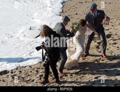 Sposa catturati da onda sulla spiaggia, Newquay, Cornwall, Regno Unito. Foto Stock