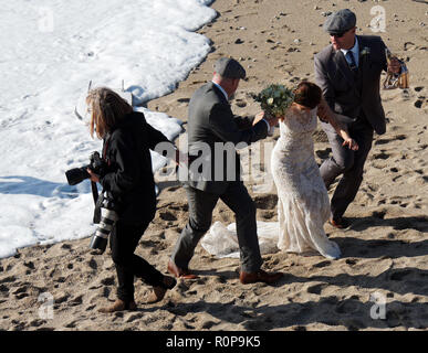 Sposa catturati da onda sulla spiaggia, Newquay, Cornwall, Regno Unito. Foto Stock