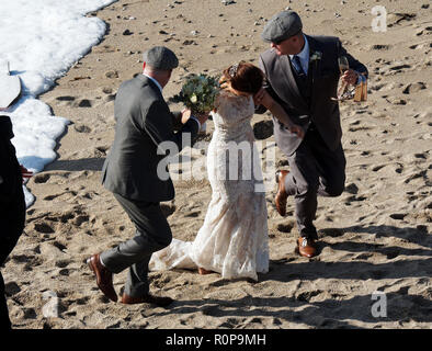 Sposa catturati da onda sulla spiaggia, Newquay, Cornwall, Regno Unito. Foto Stock