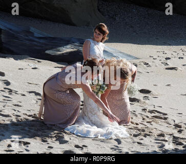 Sposa catturati da onda sulla spiaggia, Newquay, Cornwall, Regno Unito. Foto Stock