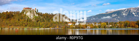 Il lago di Bled in Slovenia vista panoramica con castello, città e alberi d'autunno nelle Alpi Giulie montagne Foto Stock