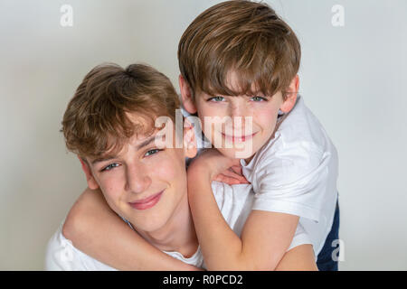 Sfondo bianco studio fotografia del giovane ragazzo felici i bambini fratelli insieme sorridente Foto Stock
