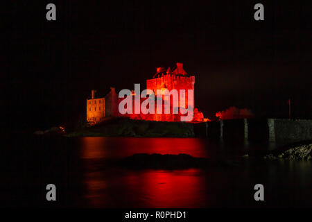 Dornie, Scozia. 6 Novembre, 2018. Eilean Donan Castle, Dornie, regione delle Highlands, Scozia illuminato in rosso durante la notte per sostenere il papavero Scozia 'luce rossa" campagna per 2018. Edifici iconici e punti di riferimento in tutta la Scozia stanno mostrando il supporto per il papavero scozzese appello mediante illuminazione rossa in esecuzione fino al Giorno del Ricordo. Cliff verde/Alamy Live News Foto Stock