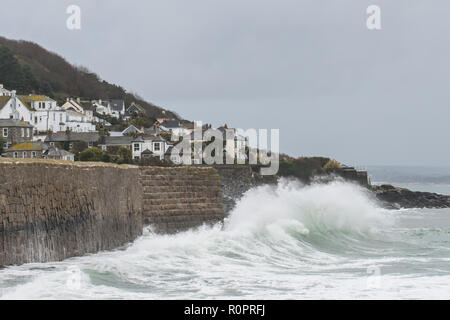 Mousehole, Cornwall, Regno Unito. Il 7 novembre 2018. Regno Unito Meteo. A seguito di stoviglie rosse di alta venti vi era una buona si gonfiano sul mare a Mousehole questa mattina, ideale per una coppia di mattina presto surfers, surf appena al di fuori della parete del porto. Credito: Simon Maycock/Alamy Live News Foto Stock