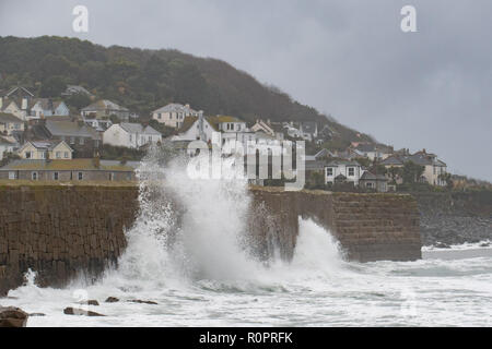 Mousehole, Cornwall, Regno Unito. Il 7 novembre 2018. Regno Unito Meteo. A seguito di stoviglie rosse di alta venti vi era una buona si gonfiano sul mare a Mousehole questa mattina, ideale per una coppia di mattina presto surfers, surf appena al di fuori della parete del porto. Credito: Simon Maycock/Alamy Live News Foto Stock