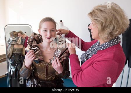 07 novembre 2018, Sassonia, Dresda: Michelle Klinkenberg (l), un terzo anno di apprendista pasticcere, indossa un abito per il prossimo Choco Classico sagra del cioccolato (9 a 11 Novembre 2018) in un armadietto a Dresda università di scienze applicate al fianco di maestro sarto Ines Günnel. Il vestito è stato progettato dagli studenti di design della Fachhochschule di Dresda e sarà presentato in occasione della Sagra del Cioccolato. Foto: Sebastian Kahnert/dpa-Zentralbild/ZB Foto Stock