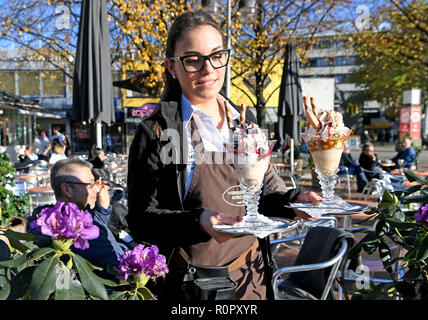 Hannover, Germania. 07 Nov, 2018. Anna serve gelati sundaes sulla terrazza della Venezia gelateria nel centro della città di minore capitale della Sassonia. Il termometro in parti della Bassa Sassonia è di origine poco al di sotto di 20 gradi centigradi in questo giorno di autunno caldo. Credito: Holger Hollemann/dpa/Alamy Live News Foto Stock