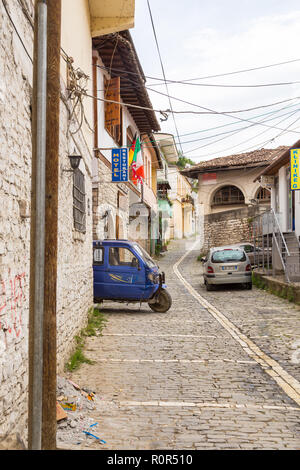 Berat, Albania- 30 giugno 2014: strette vie pavimentate con veicoli nella storica città di Berat. Architettura ottomana in Albania, Unesco World Herita Foto Stock