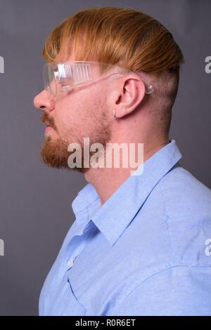 Uomo Barbuto medico con capelli biondi indossando occhiali protettivi ag Foto Stock