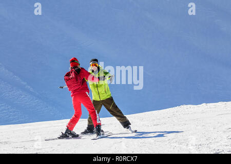 Sochi, Russia - 20 Gennaio 2013: Maschio istruttore insegna sci al giovane donna sul pendio della montagna in Krasnaya Polyana. Foto Stock