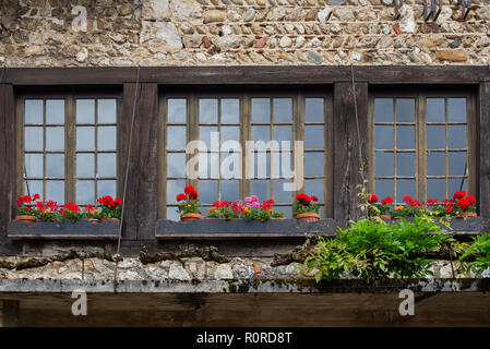 Finestra con gerani rossi finestre lungo una strada nella bellissima zona collinare medievale città murata di PEROUGES, Francia Foto Stock