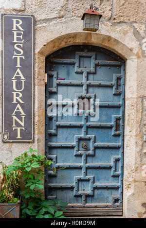 Porta a un ristorante lungo una strada nella bellissima zona collinare medievale città murata di PEROUGES, Francia Foto Stock
