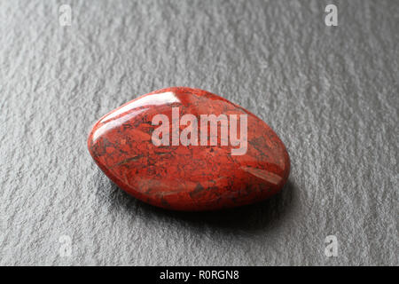 Diaspro Rosso pietra su una pietra nera board Foto Stock