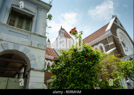 Vista di tutti i santi della Chiesa Anglicana, situato in Forte Galle, Sri Lanka. Tetti rossi stagliano contro un blu cielo nuvoloso. Foto Stock