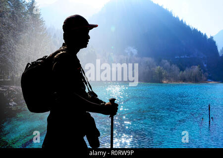 Trekker sensazione di stanchezza e di appoggio al colorato turchese lago nella stagione primaverile - Jiuzhaigou, Cina Foto Stock