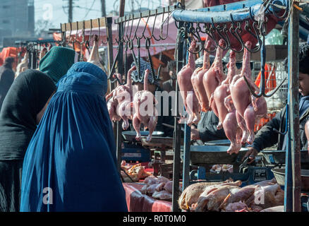 Macellaio Vendita di pollo senza pelle per donne che indossano Burqa blu a Mazar-e Sharif Central Bazaar, Maraz-e Sharif, Balkh Provincia, Afghanistan Foto Stock