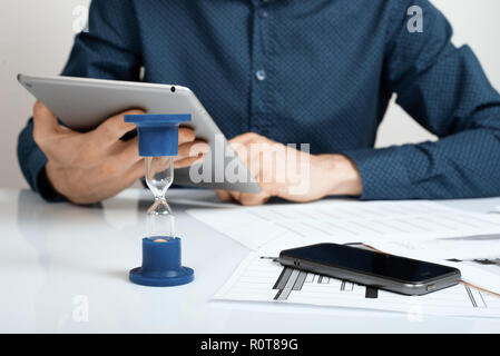 Close up di imprenditore il canto analizzando il grafico su tavoletta digitale. Il tempo è denaro concetto. Foto Stock