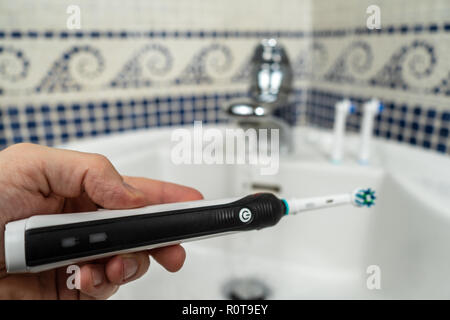 Elettrico spazzolino ricaricabile con un manico nero e le testine di spazzolini da denti Foto Stock