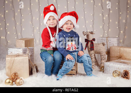 Ritratto di white Caucasian bambini felici del fratello e sorella indossando Santa Claus cappelli per celebrare il Natale. Poco carino adorabile ragazzo e ragazza siblin Foto Stock