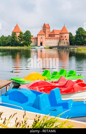 Barche per i turisti di fronte all'Isola di Trakai Castle. Trakai, Contea di Vilnius, Lituania, paesi baltici, Europa. Foto Stock