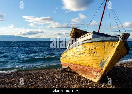 Legno giallo del pescatore a filamento in barca al Cile Chilo spiaggia di Playa Grande, la sponda meridionale del lago General Carrera Foto Stock