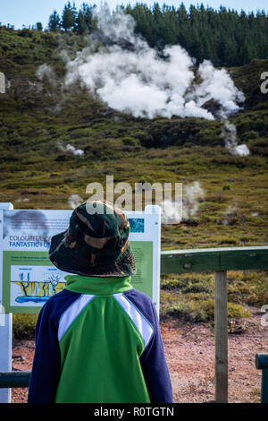 Bambino di istruzione di lettura scheda di informazione presso i crateri della luna (Karapiti in Māori) Passerella geotermica, Taupo, Isola del nord, Nuova Zelanda Foto Stock