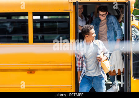 Un gruppo di studiosi di teen di camminare al di fuori della scuola bus