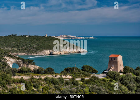 La Torre di San Felice, antica torre di avvistamento San Felice Arch, città di Vieste in lontananza oltre il mare Adriatico, Puglia, Italia Foto Stock