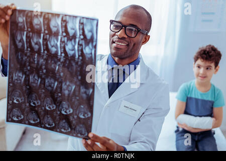 Felice medico maschile seduto nel suo studio Foto Stock