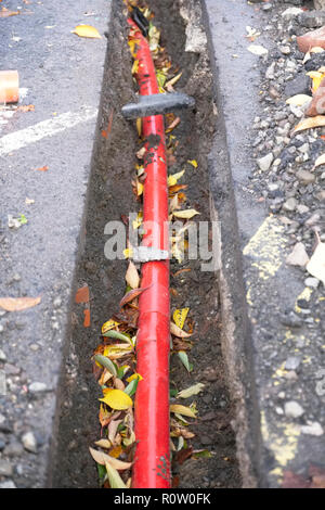 Metropolitana Rossa elettrico condotto per cavi in trincea in costruzione cantiere Foto Stock