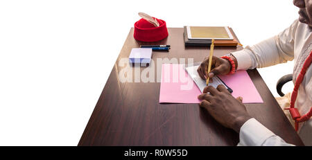 Un africano business man segni un controllo presso il suo ufficio tavolo e la scrittura su una tabella con jotter, pen tablet con uno sfondo bianco. Le mani si vede nella Foto Stock