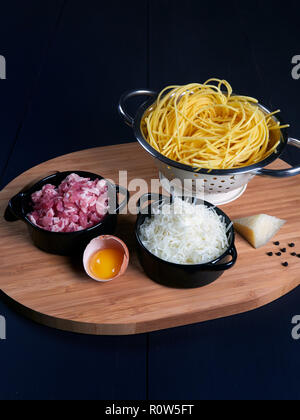 Ingredienti per spaghetti alla carbonara: spaghetti freschi, pecorino romano grattugiato, pancetta o guanciale), tuorlo d'uovo, pepe nero in grani Foto Stock