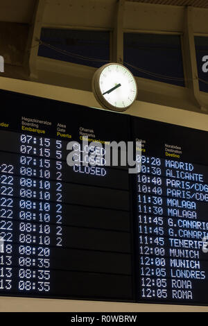 Partenza del volo e orario di arrivo pannello in aeroporto con orologio sulla parte superiore. Traduzione Lingua: Londra, Roma Foto Stock