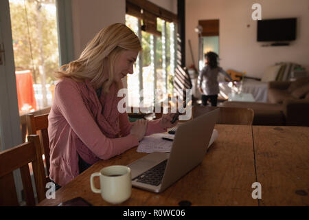 Donna che utilizza il telefono cellulare a casa Foto Stock