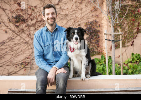 Ritratto di graphic designer Andrew Knapp con il suo cane Momo, un Border Collie, in un arresto di Lisbona, durante il viaggio attraverso l'Europa. Foto Stock