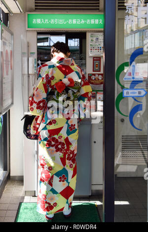 Donna Giapponese in un kimono con automatic teller, Kyoto, Giappone Foto Stock