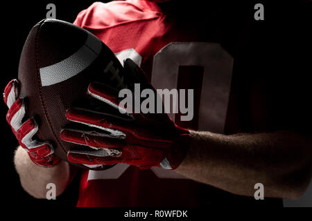 Giocatore di football americano tenendo palla da rugby Foto Stock