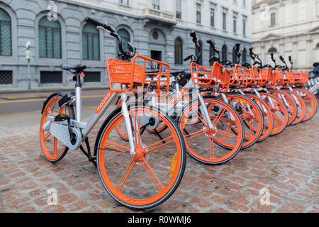 Milano, Italia - 27 Ottobre 2018: Piazza della Scala, noleggio di biciclette parcheggiate in una fila sulla piazza. L'arancio e silver le biciclette sono da Mobike, un com Foto Stock