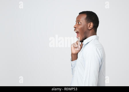 Una vista laterale di giovani africani handsome man standing avente eccellente idea Foto Stock
