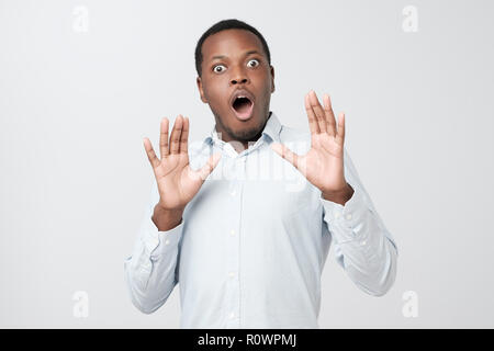 L'uomo africano avente storditi e scioccato guardare ascoltare amici storia in incredulità Foto Stock