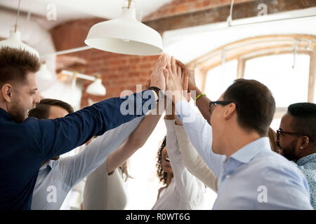 Close up di diversi lavoratori dare alta cinque alla riunione Foto Stock