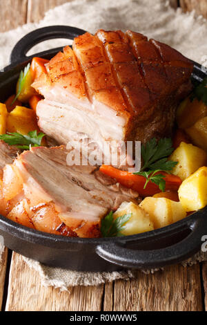 La birra bavarese arrosto di maiale, noto anche come Bayerischer Schweinebraten Krustenbraten o con verdure close-up in una padella verticale. Foto Stock