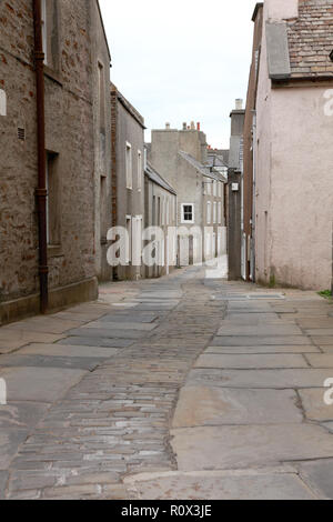 Alfred Street in Stromness, Orkney con vecchie pietre per pavimentazione da una cava in Orphir e ciottoli nel centro della strada. Foto Stock