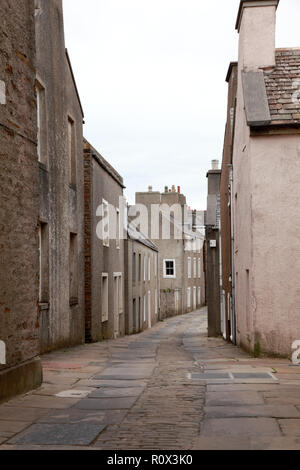 Alfred Street in Stromness, Orkney con vecchie pietre per pavimentazione da una cava in Orphir e ciottoli nel centro della strada Foto Stock